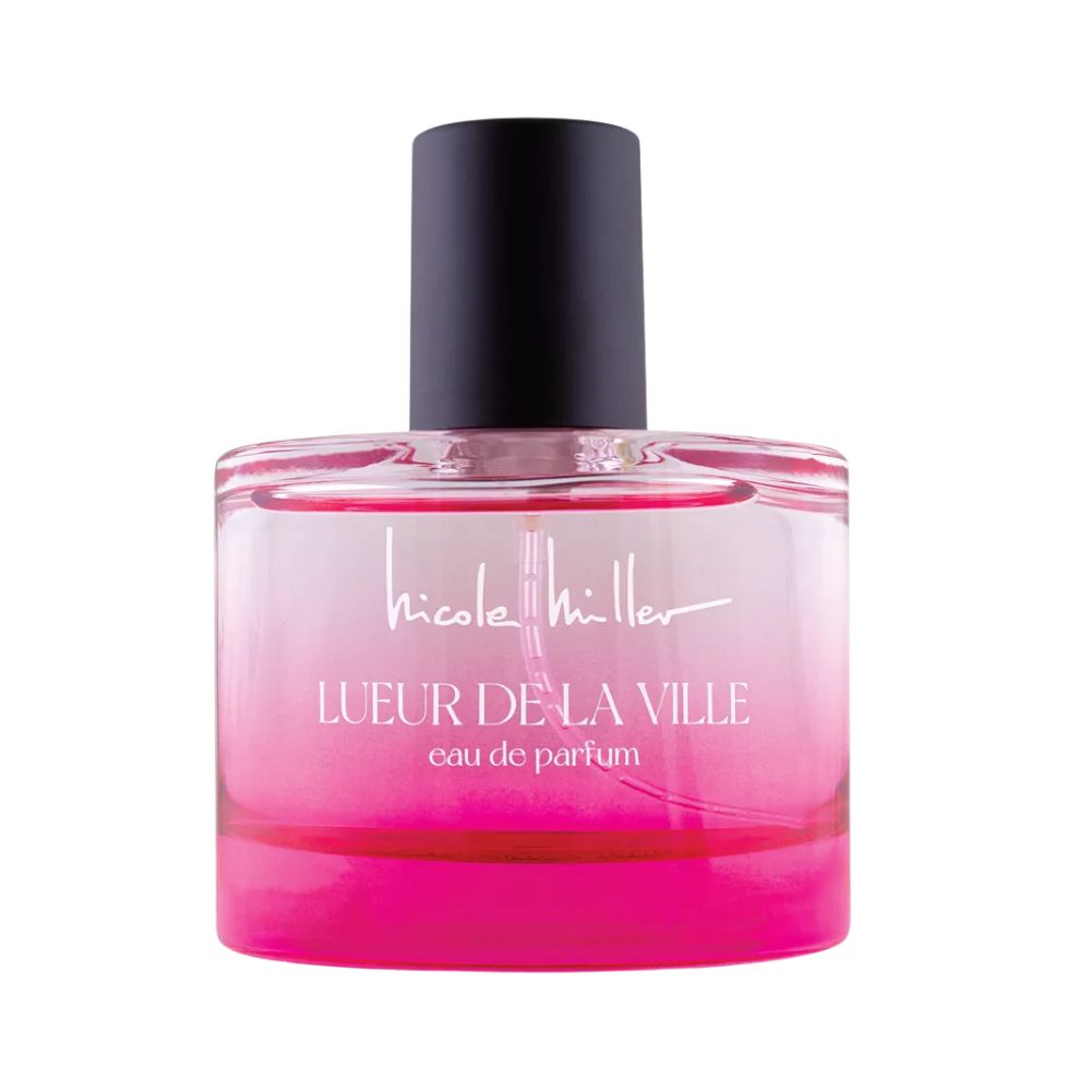 Bouteille de parfum rose avec un bouchon noir et le texte "Lueur de la Ville".